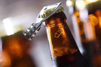 Photo of Opening bottle of beer on blurred grey background, closeup