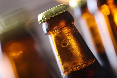 Photo of Bottle of tasty beer on blurred grey background, macro view