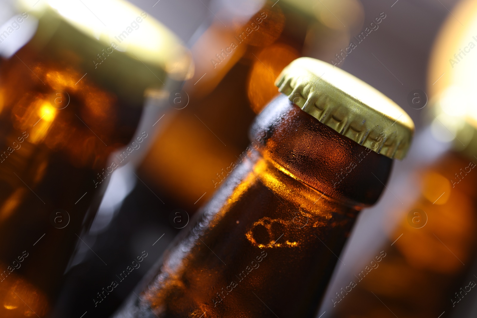 Bottle of tasty beer on blurred grey background, macro view Photo of Bottle of tasty beer on blurred grey background, macro view