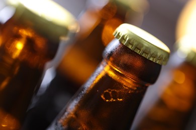 Photo of Bottle of tasty beer on blurred grey background, macro view