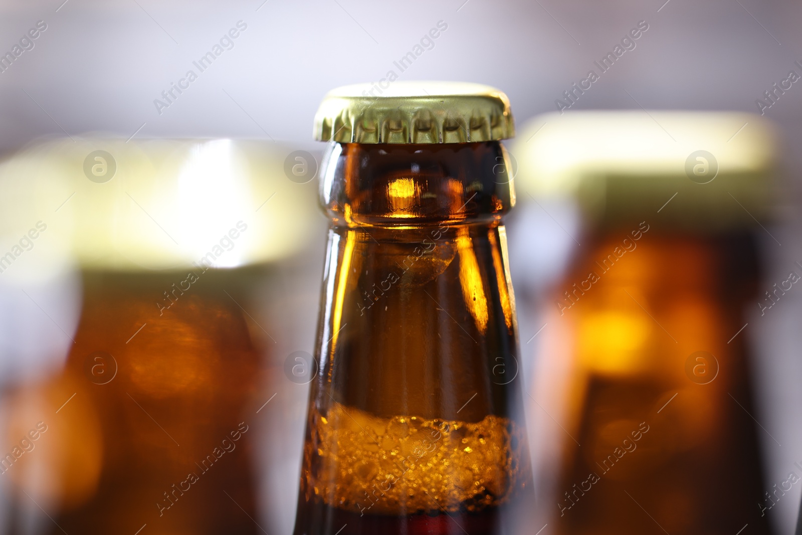 Bottle of tasty beer on blurred grey background, macro view Photo of Bottle of tasty beer on blurred grey background, macro view