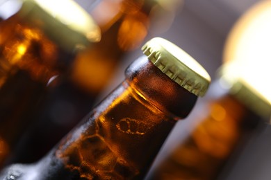 Photo of Bottle of tasty beer on blurred grey background, macro view