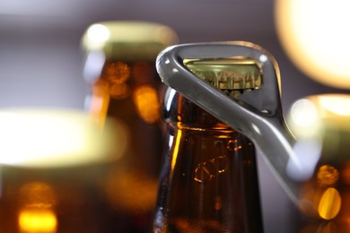 Photo of Opening bottle of beer on blurred grey background, closeup