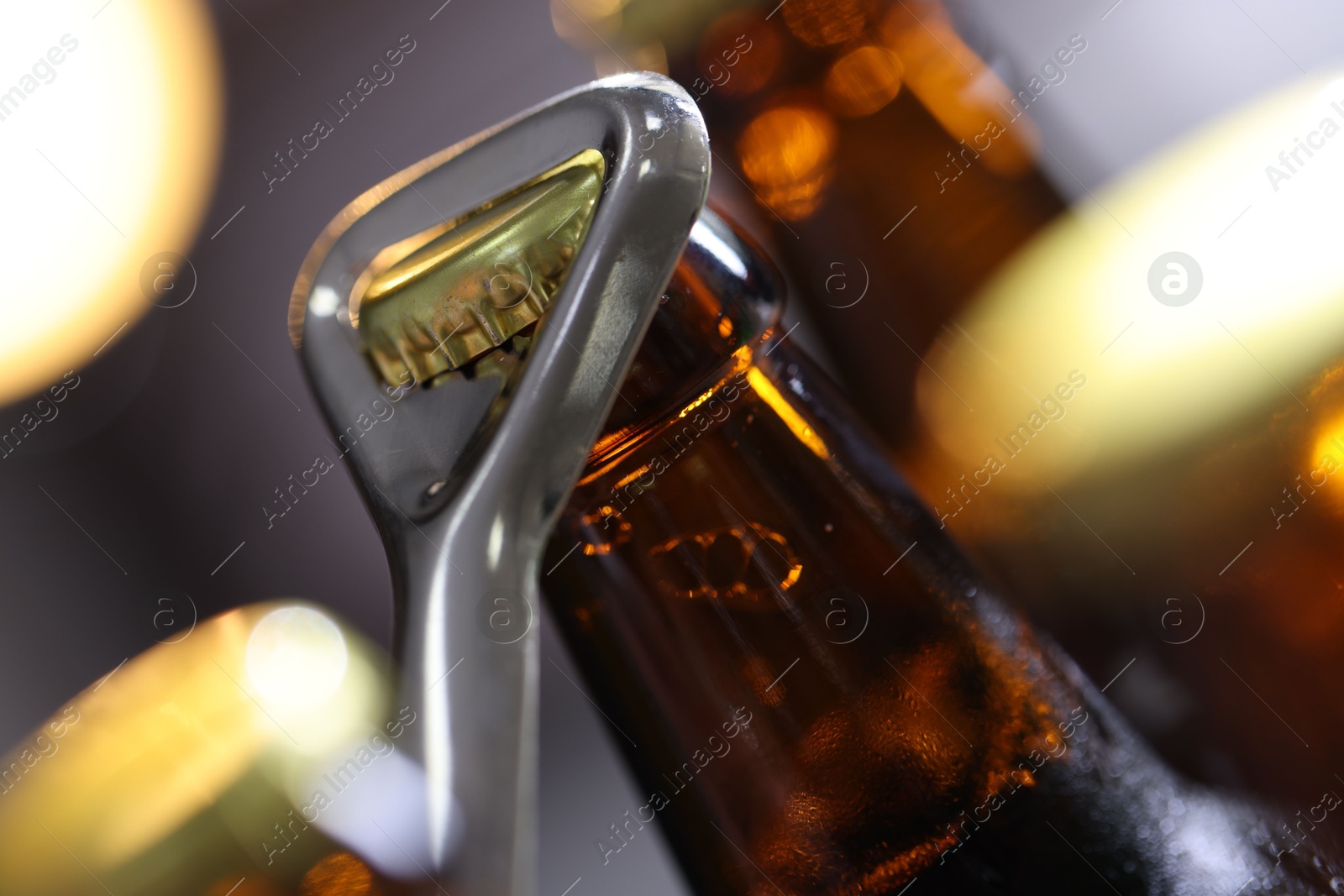 Opening bottle of beer on blurred grey background, closeup Photo of Opening bottle of beer on blurred grey background, closeup