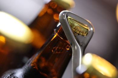 Photo of Opening bottle of beer on blurred grey background, closeup