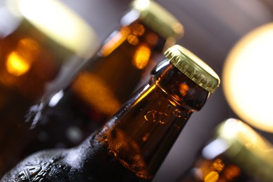 Photo of Bottle of tasty beer on blurred grey background, macro view