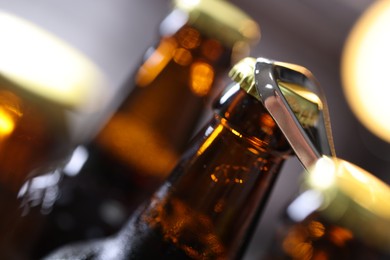 Photo of Opening bottle of beer on blurred grey background, closeup