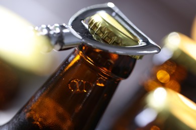 Photo of Opening bottle of beer on blurred grey background, closeup