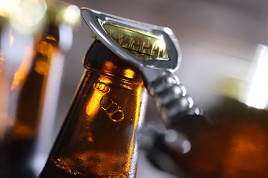 Photo of Opening bottle of beer on blurred grey background, closeup