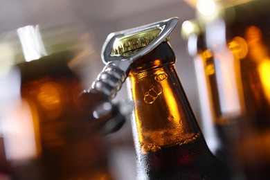 Photo of Opening bottle of beer on blurred grey background, closeup