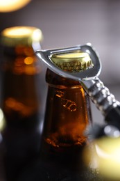 Photo of Opening bottle of beer on blurred grey background, closeup