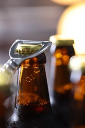 Photo of Opening bottle of beer on blurred grey background, closeup