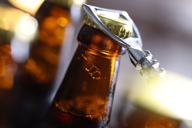 Photo of Opening bottle of beer on blurred grey background, closeup