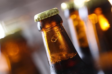 Photo of Bottle of tasty beer on blurred grey background, macro view