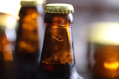 Photo of Bottle of tasty beer on blurred grey background, macro view