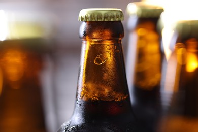 Photo of Bottle of tasty beer on blurred grey background, macro view