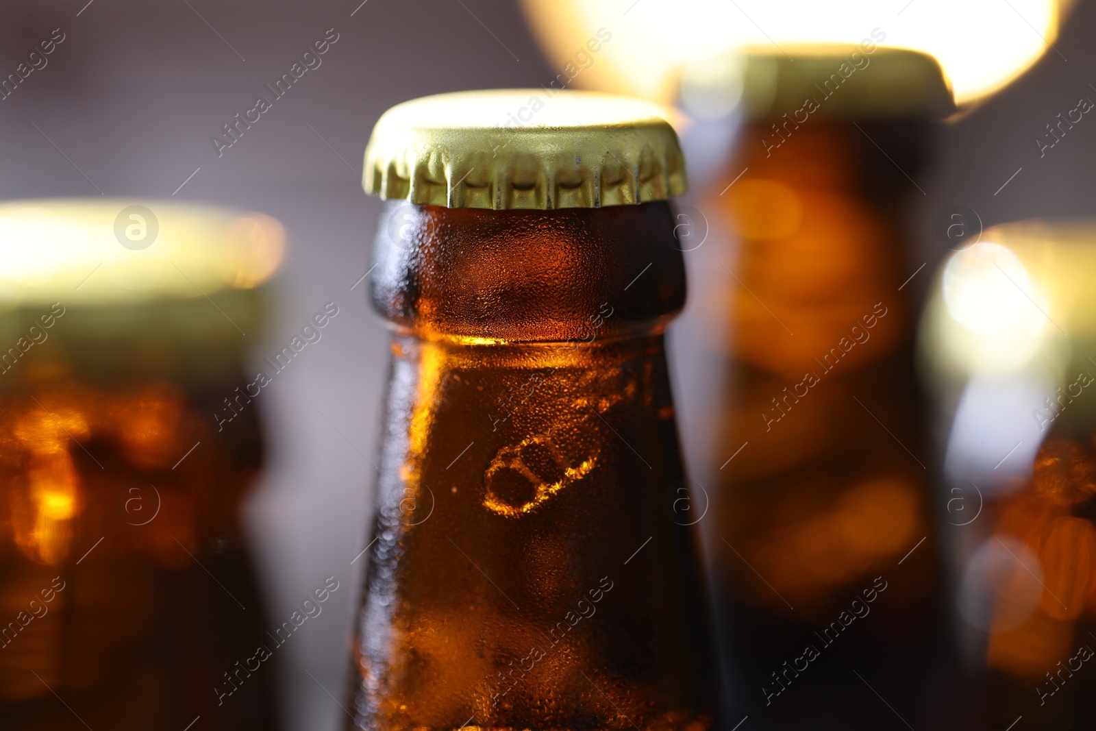Bottle of tasty beer on blurred grey background, macro view Photo of Bottle of tasty beer on blurred grey background, macro view