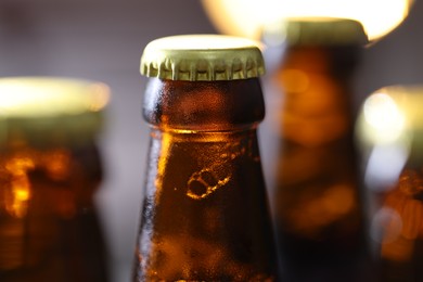Photo of Bottle of tasty beer on blurred grey background, macro view