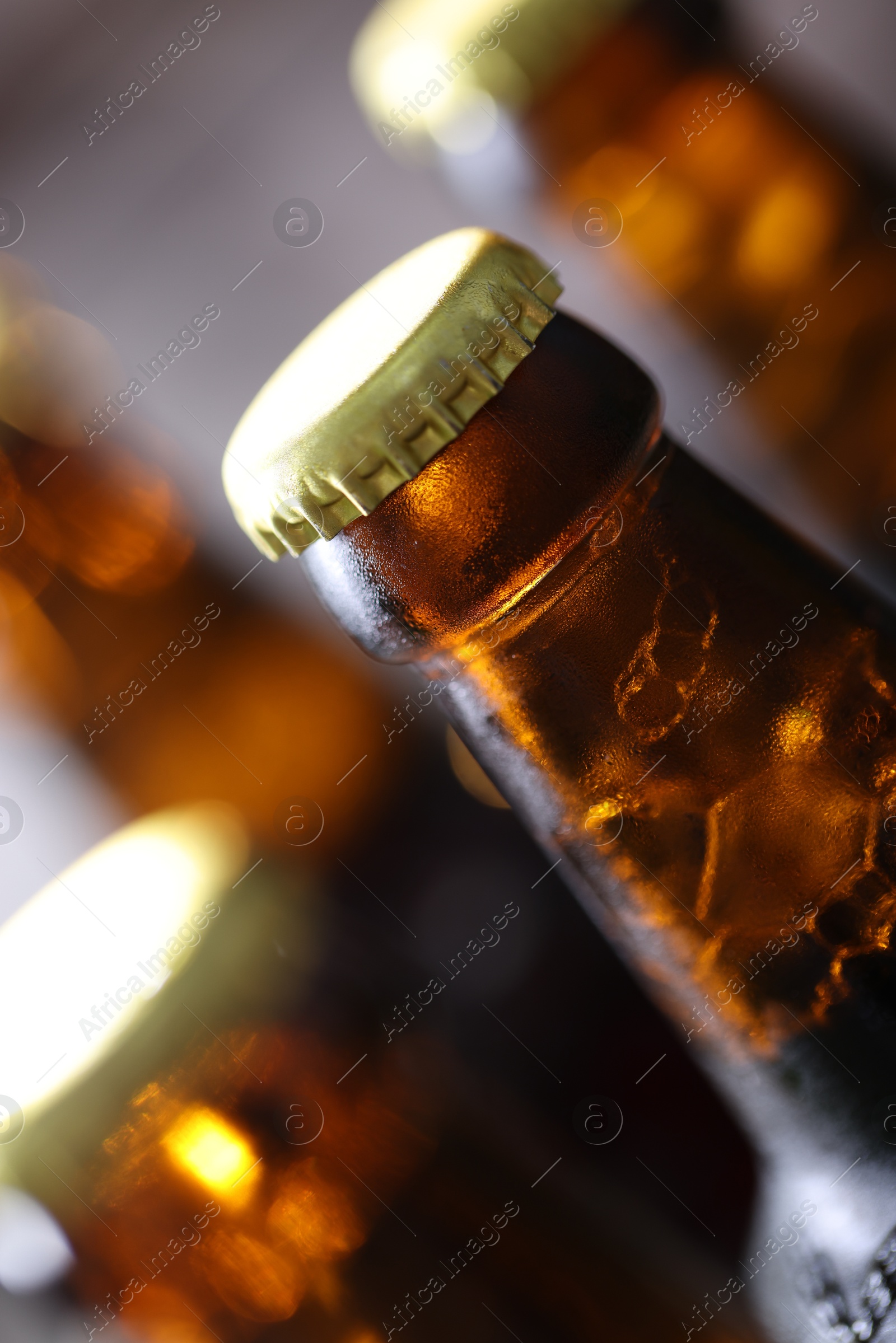 Bottle of tasty beer on blurred grey background, macro view Photo of Bottle of tasty beer on blurred grey background, macro view