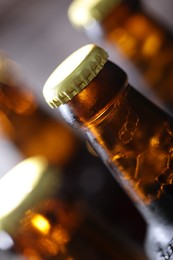 Photo of Bottle of tasty beer on blurred grey background, macro view