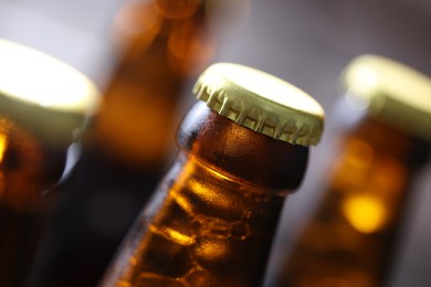 Photo of Bottle of tasty beer on blurred grey background, macro view