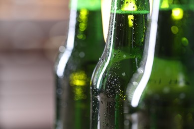 Photo of Bottles of beer on blurred grey background, macro view