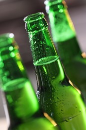 Photo of Bottles of beer on blurred grey background, macro view
