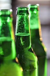 Photo of Bottles of beer on blurred grey background, macro view