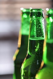 Photo of Bottles of beer on blurred grey background, macro view