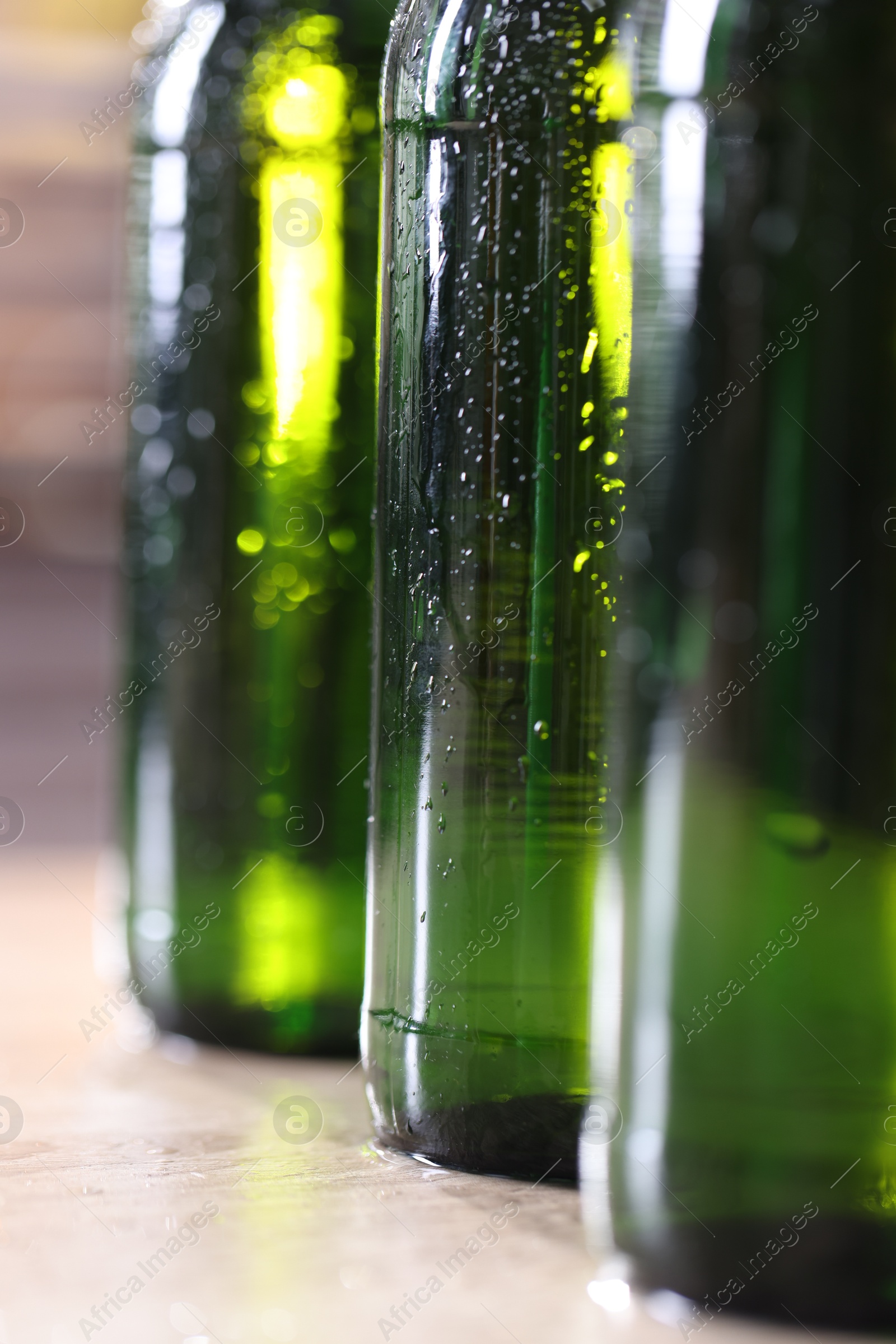 Bottles of beer on wooden table, macro view Photo of Bottles of beer on wooden table, macro view