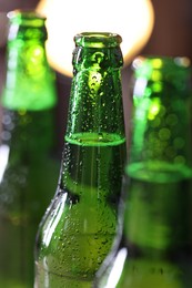 Photo of Bottles of beer on blurred background, macro view