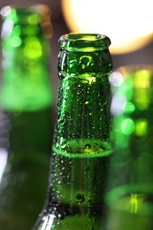 Photo of Bottles of beer on blurred background, macro view
