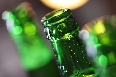 Photo of Bottle of tasty beer on blurred grey background, macro view