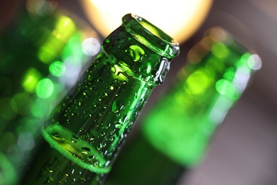 Photo of Bottle of tasty beer on blurred grey background, macro view