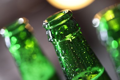 Photo of Bottle of tasty beer on blurred grey background, macro view