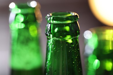 Photo of Bottle of tasty beer on blurred grey background, macro view