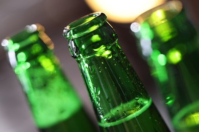 Photo of Bottle of tasty beer on blurred grey background, macro view