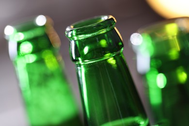 Photo of Bottle of tasty beer on blurred grey background, macro view