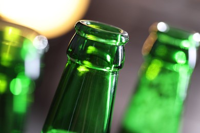 Photo of Bottle of tasty beer on blurred grey background, macro view