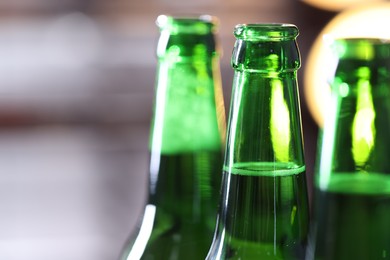 Photo of Bottles of beer on blurred grey background, macro view. Space for text