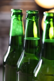 Photo of Bottles of beer on blurred grey background, macro view
