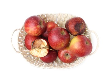 Photo of Spoiled apple and good ones in basket isolated on white, top view