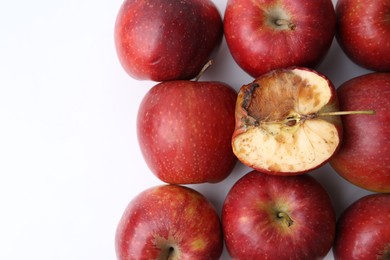 Photo of Spoiled apple and good ones on white background, flat lay