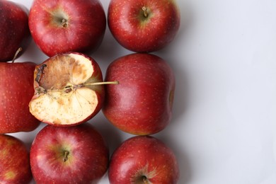 Photo of Spoiled apple and good ones on white background, flat lay