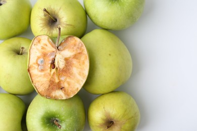 Photo of Spoiled apple and good ones on white background, flat lay