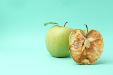 Photo of Spoiled apple and good ones on turquoise background