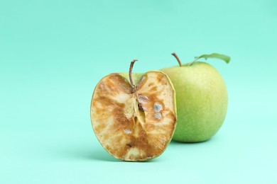 Photo of Spoiled apple and good ones on turquoise background