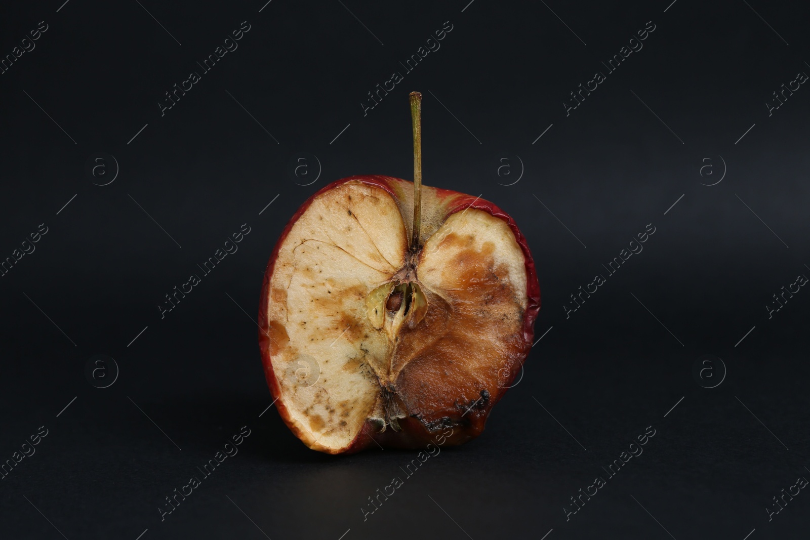 Half of spoiled apple on black background Photo of Half of spoiled apple on black background