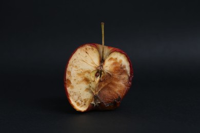 Photo of Half of spoiled apple on black background