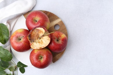Photo of Spoiled apple and good ones on white table, flat lay. Space for text